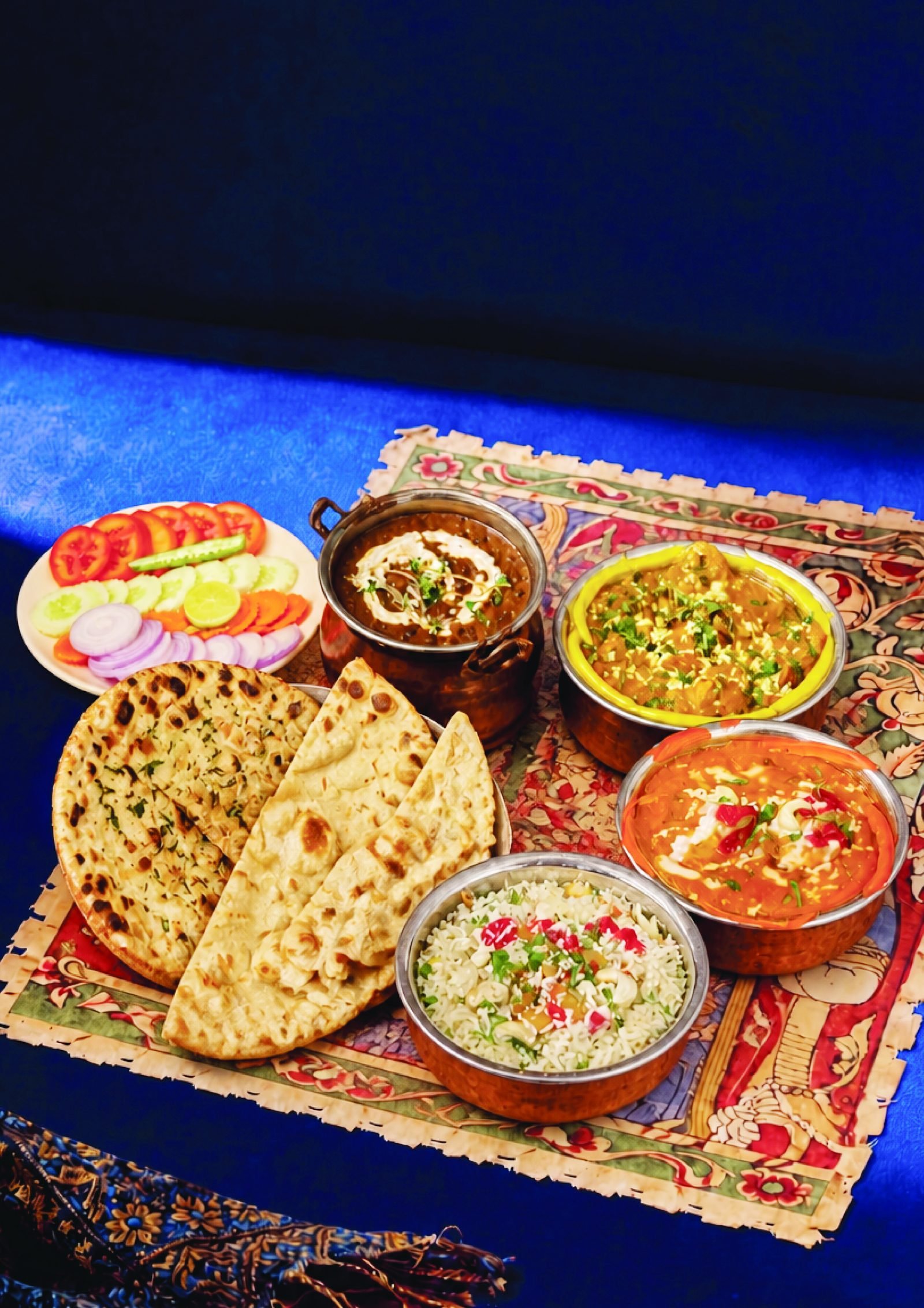 Thali spread with naan, paneer curries and rice